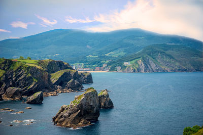 Scenic view of sea and mountains against sky