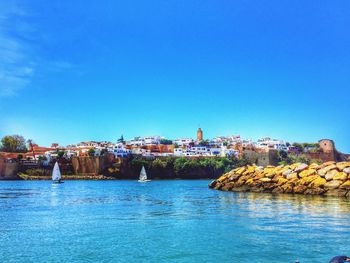 View of town in sea against blue sky