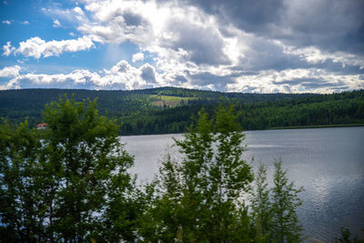 Scenic view of lake and mountains against cloudy sky