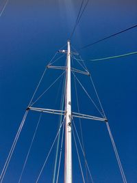 Low angle view of sailboat against blue sky