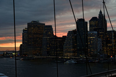 Illuminated buildings against sky at sunset