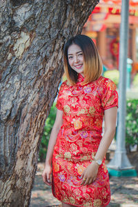 Young woman standing on tree trunk