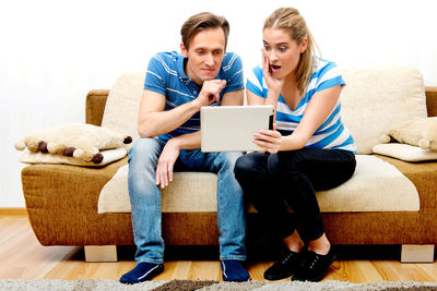 Young couple sitting on sofa at home
