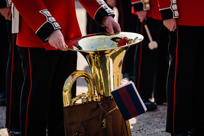 Low section of people holding musical instrument