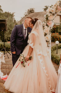 Low section of bride holding bouquet