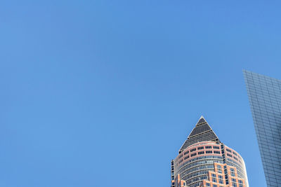 Low angle view of skyscraper against clear blue sky