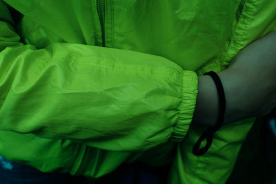 Close-up of hand holding green leaf on bed