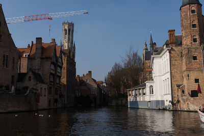 View of town by river against sky