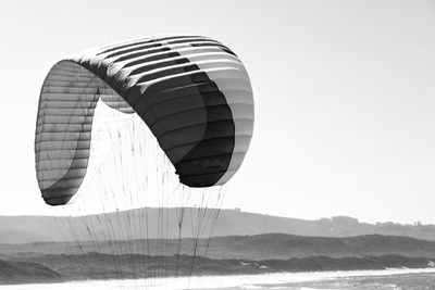 Tilt image of kite flying over mountain against sky