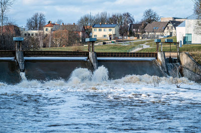 Spring flood water flows over the locks on the berze river in dobele city, latvia