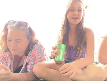 Close-up of smiling young woman sitting outdoors