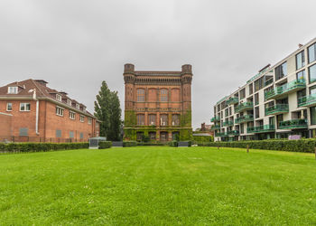 Buildings on field against sky in city