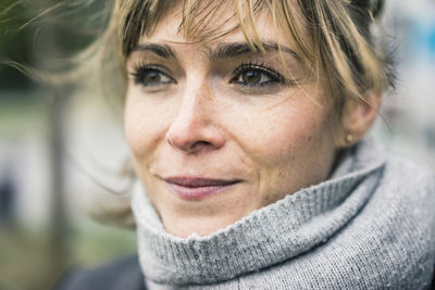 Portrait of smiling woman with scarf outdoors