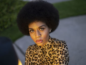 Pensive gorgeous african american female with afro hair and piercing thoughtfully looking at camera during twilight
