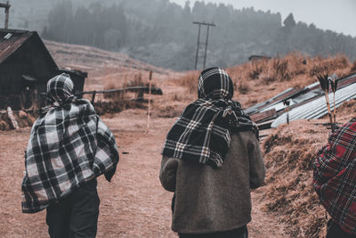 Rear view of men standing on landscape