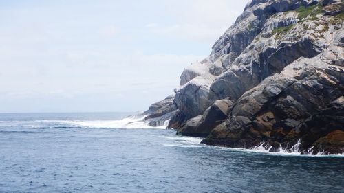 Scenic view of rocks in sea against sky