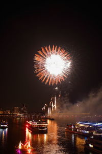 Firework display over river at night