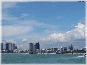 Boats in sea with city in background