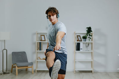 Side view of young man exercising at home