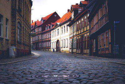 Empty alley amidst buildings in city