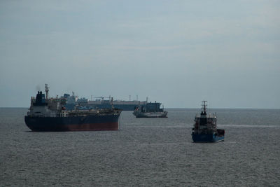 Boats sailing on sea against sky