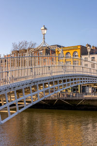 Bridge over river in city against clear sky