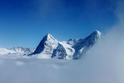 Scenic view of snowcapped mountains against clear blue sky