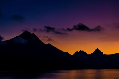 Scenic view of silhouette mountains against romantic sky at sunset