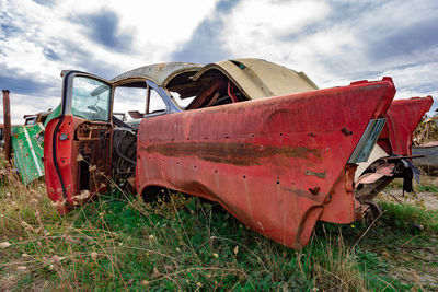 Abandoned truck on field against sky