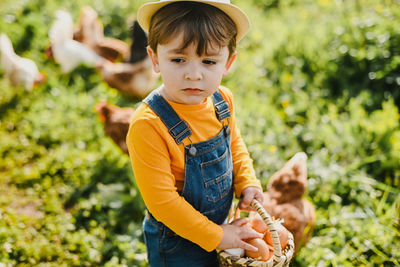 Portrait of boy standing amidst plants