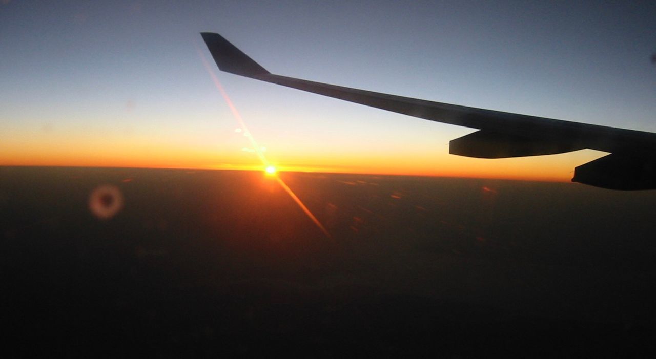 sky, air vehicle, sunset, airplane, sun, sunlight, flying, nature, aircraft wing, lens flare, beauty in nature, mode of transportation, transportation, travel, silhouette, no people, scenics - nature, sunbeam, orange color, outdoors, bright, plane