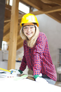 Portrait of smiling woman standing at construction site