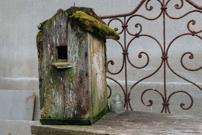 Close-up of rusty metal gate against wall