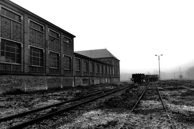 Railroad tracks amidst buildings against clear sky