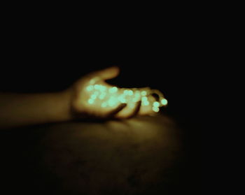Close-up of human hand against black background