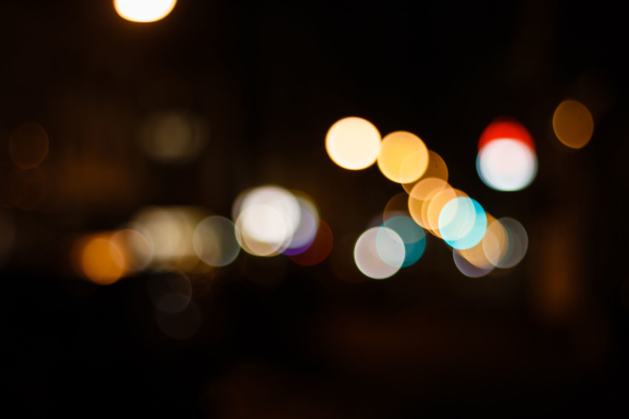 DEFOCUSED IMAGE OF ILLUMINATED LIGHTS ON STREET