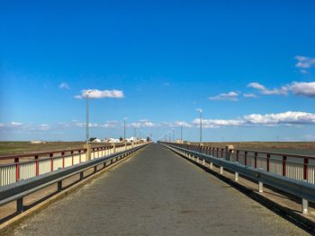 Road by bridge against sky