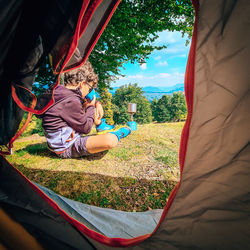 Rear view of man sitting on field