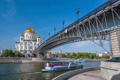 Bridge over river in city against sky