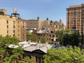 View of upper west side skyline with classic brownstones and wooden water towers.