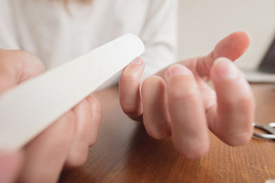 Midsection of woman doing manicure at home