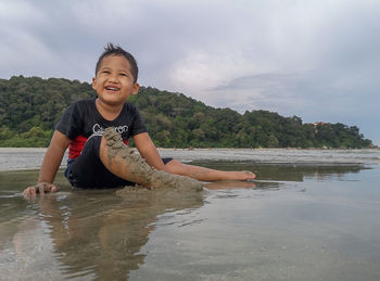 Portrait of smiling boy against sky