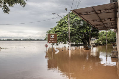 River flooding due to rain causes large mud next to a dam that prevents the rivers from meeting 