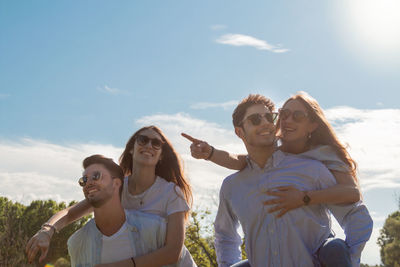 Group of young friends walking in a park while smiling - happy young group of friends