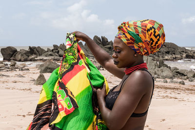 Ghana woman with headdress with beautiful african colors on a beach in ghana west africa