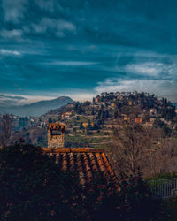 Scenic view of trees and buildings against sky