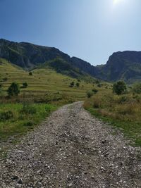 Road amidst field against sky