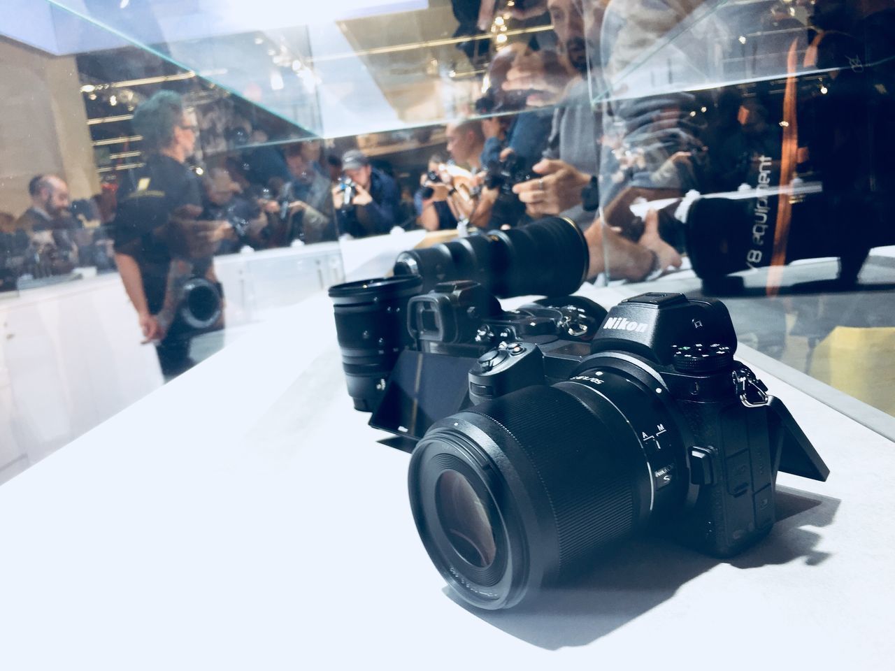 CLOSE-UP OF CAMERA WITH REFLECTION ON GLASS