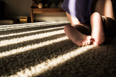 Low section of toddler crawling on carpet at home