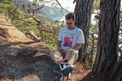 Young man sitting on rock